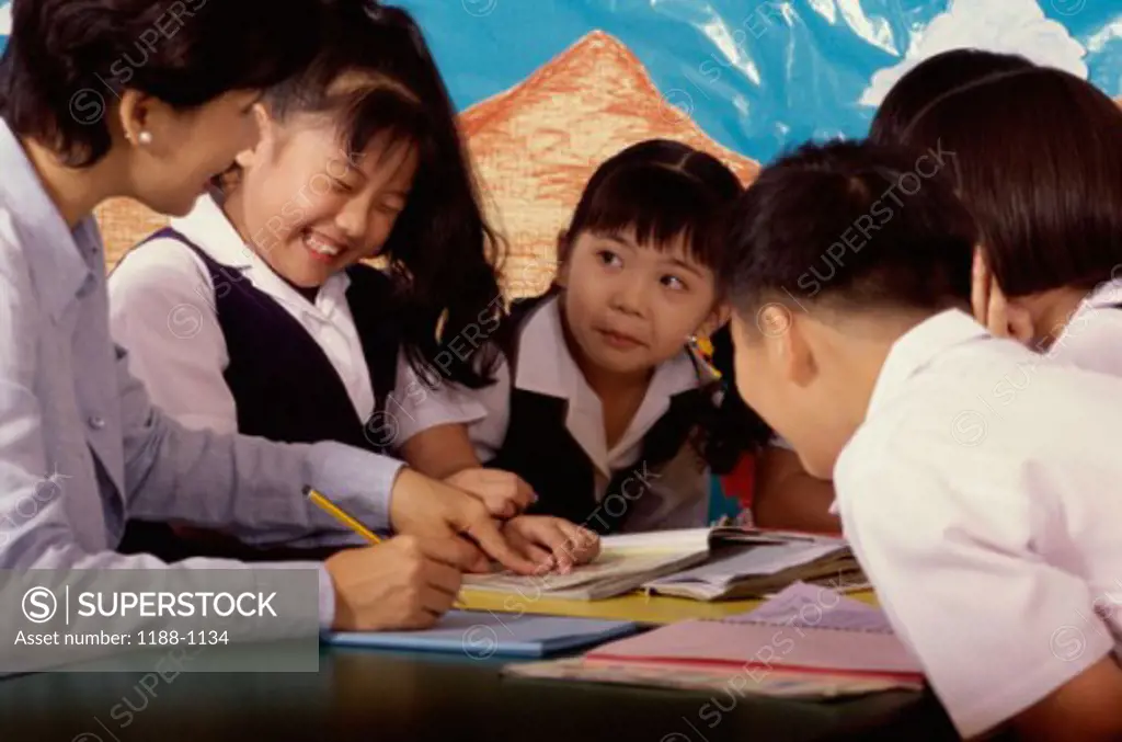 Teacher sitting with her students in a classroom