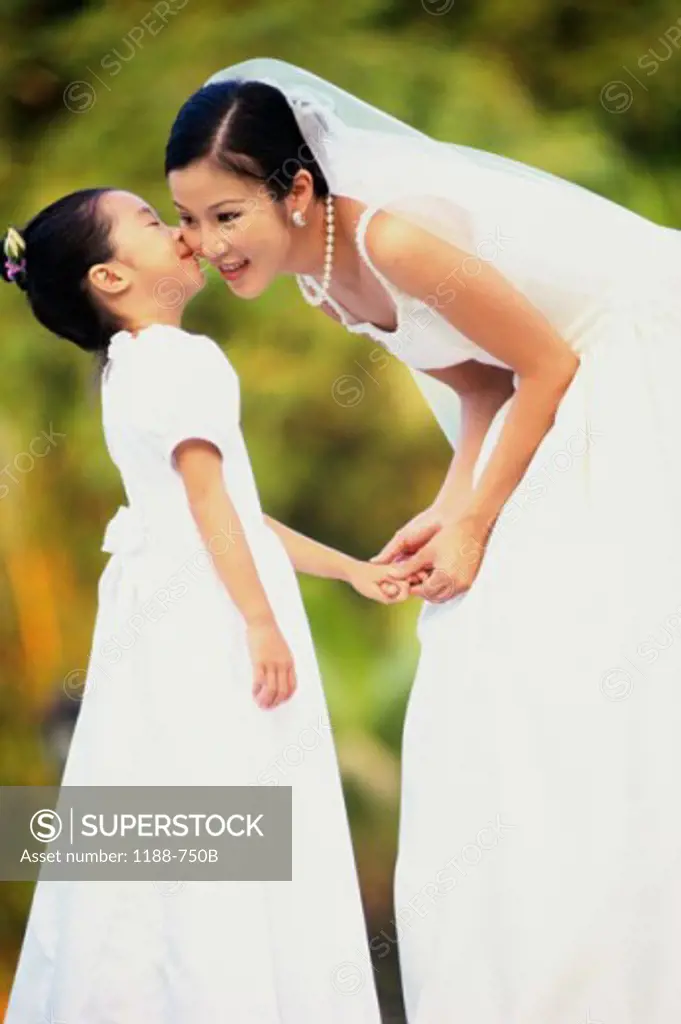 Flower girl kissing a bride