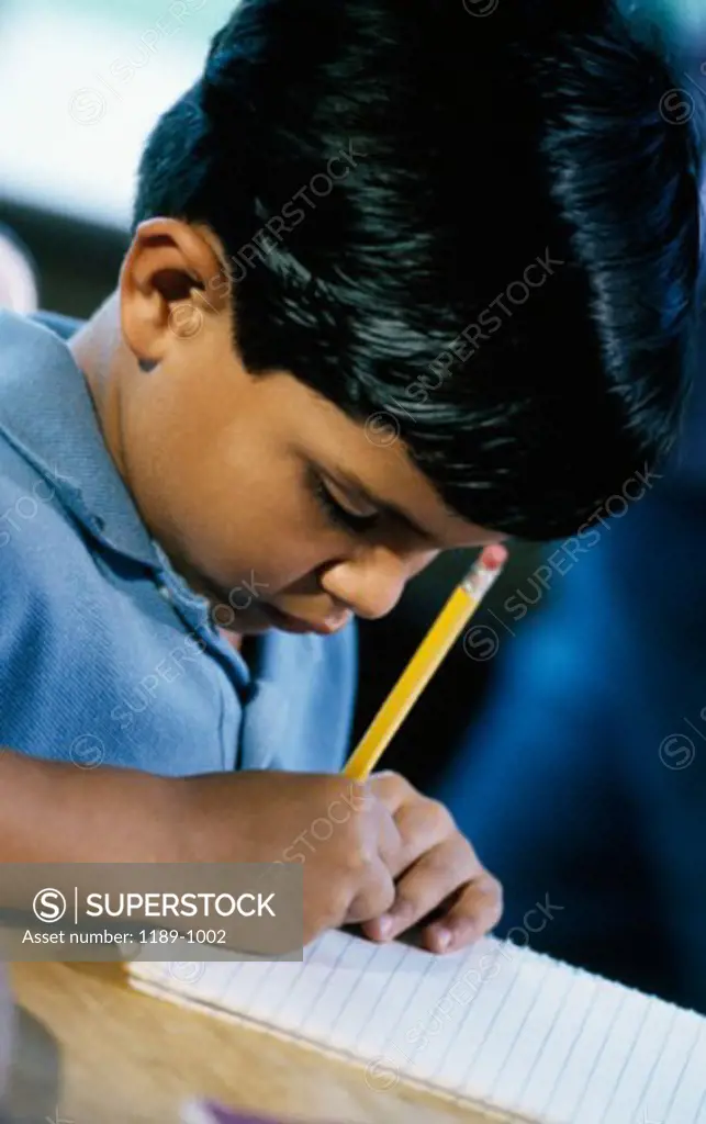 Close-up of a boy writing in a notebook