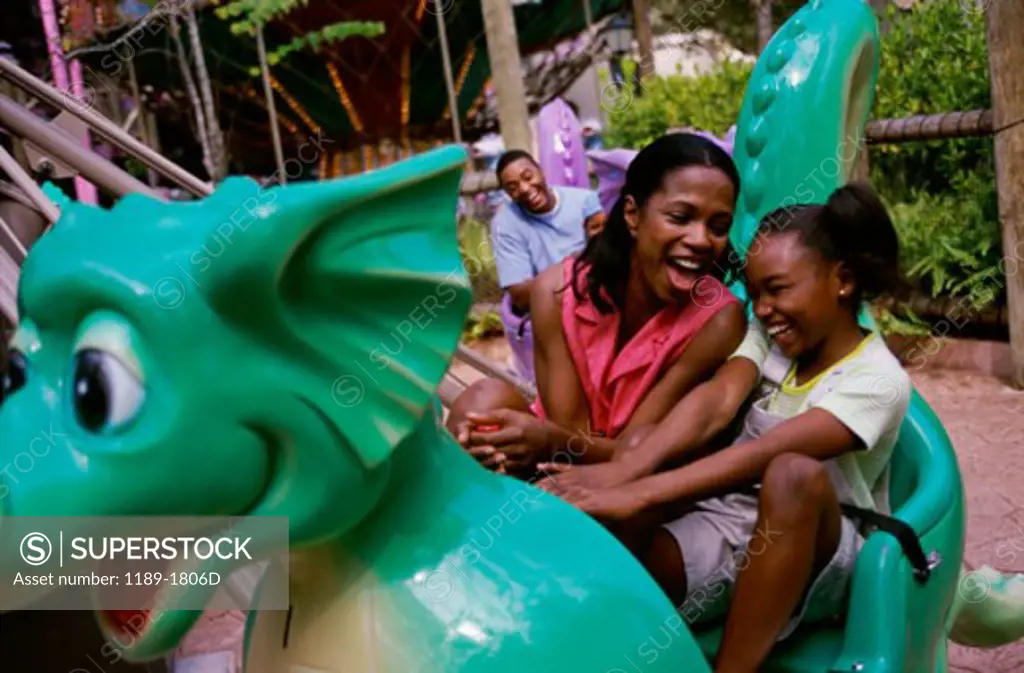 Mid adult woman with her daughter riding an amusement park ride