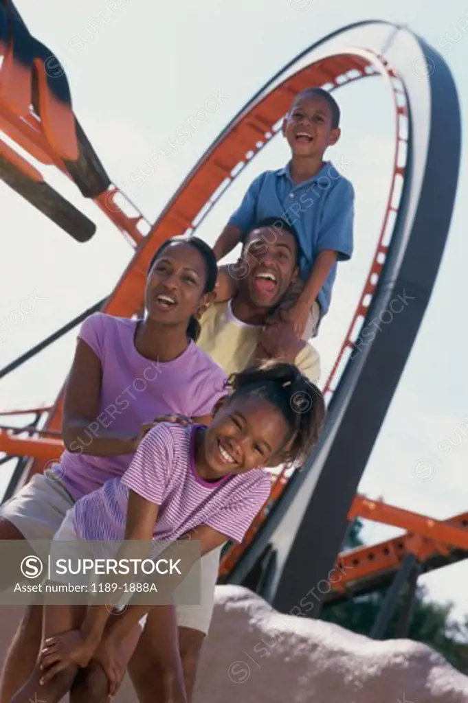 Portrait of parents with their son and daughter at an amusement park