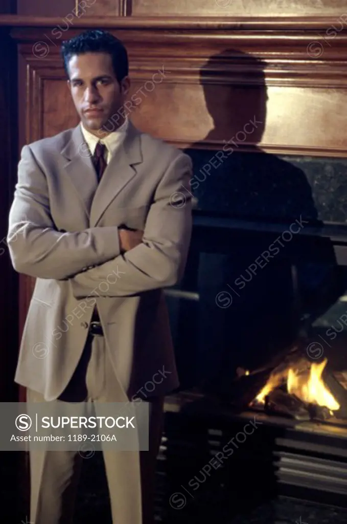 Portrait of a young man standing near a fireplace