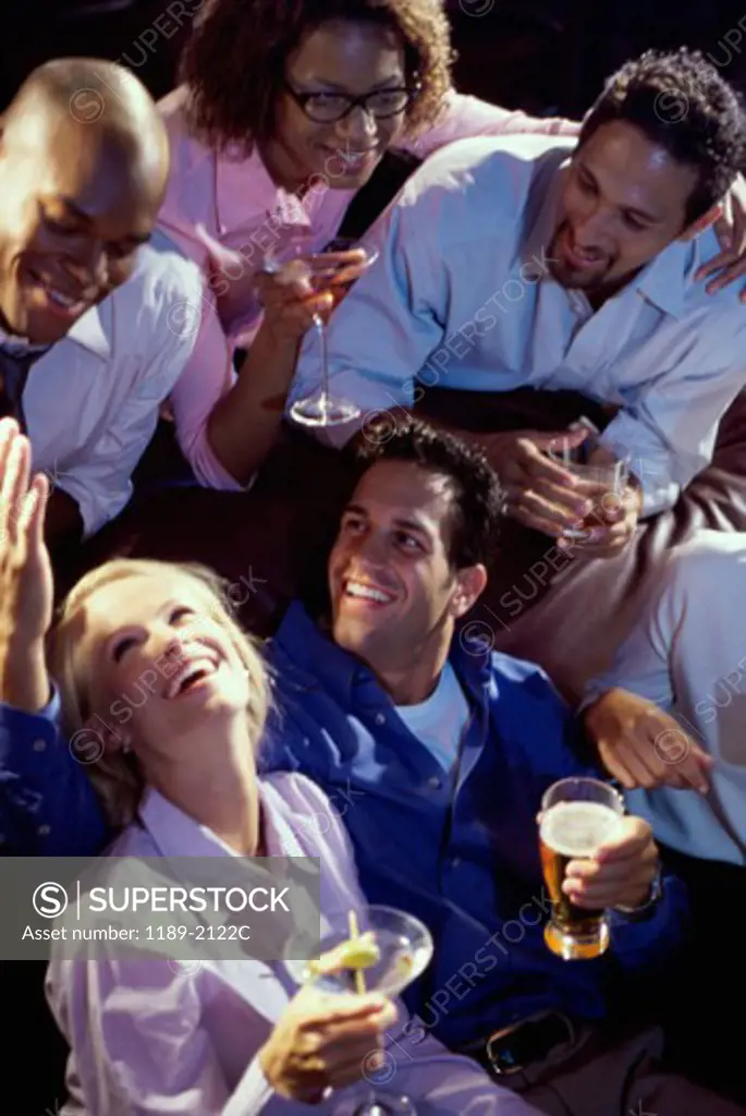 Young man with his friends celebrating in a bar and smiling