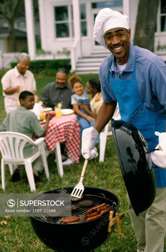 Portrait of a mid adult man barbecuing on a grill