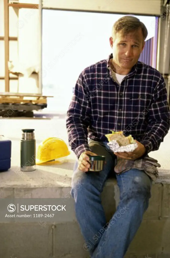 Portrait of a mid adult man holding a sandwich