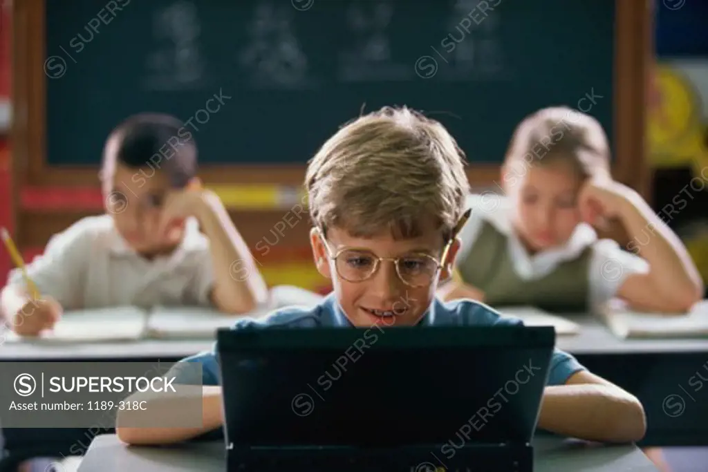 Boy using a laptop in a classroom