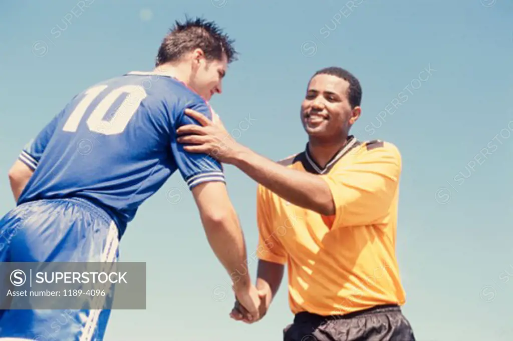 Low angle view of two soccer players shaking hands