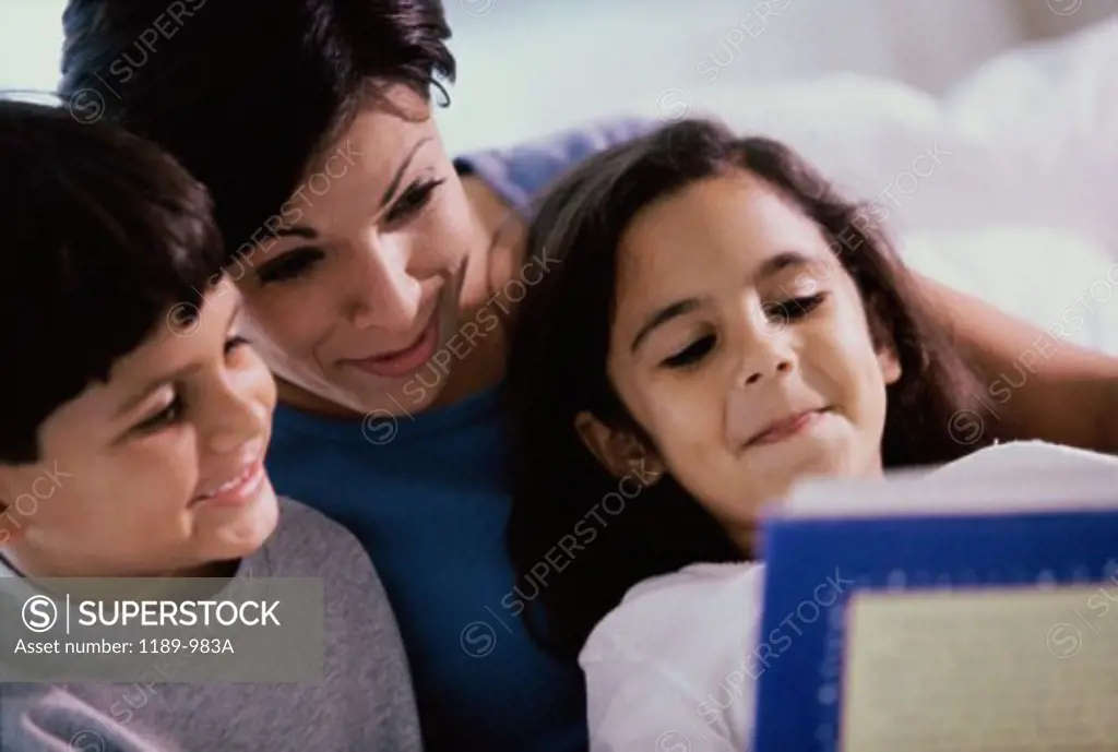 Mother and her two children reading a book