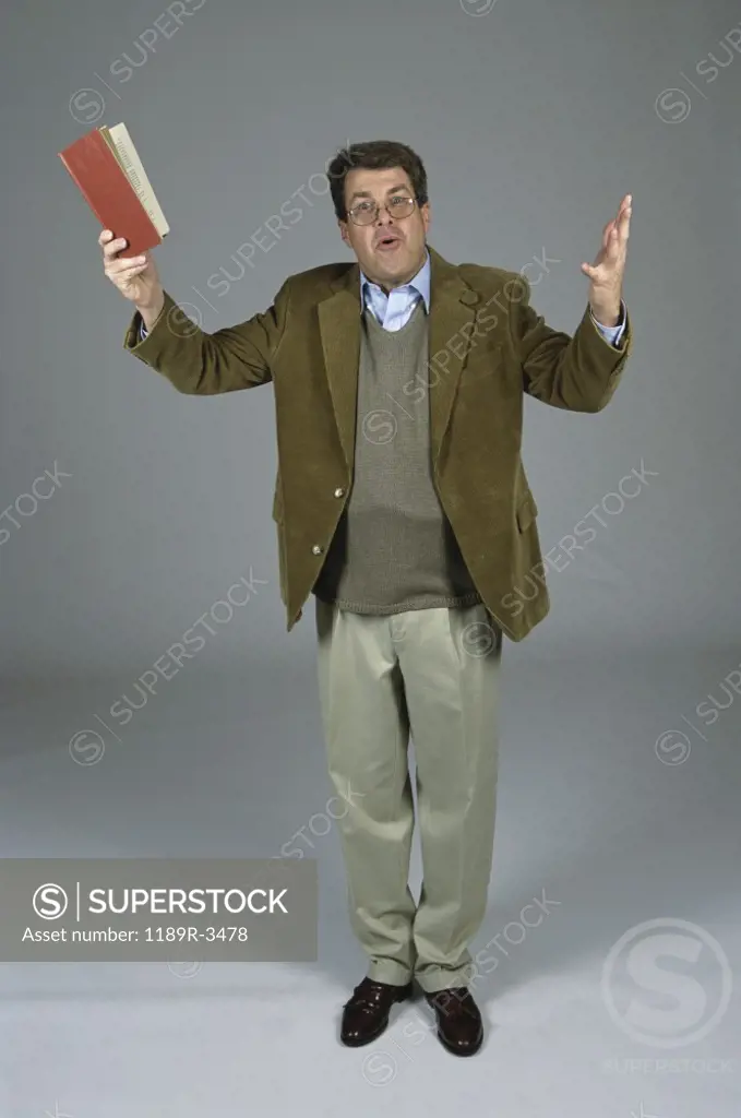 Portrait of a male professor holding up a book