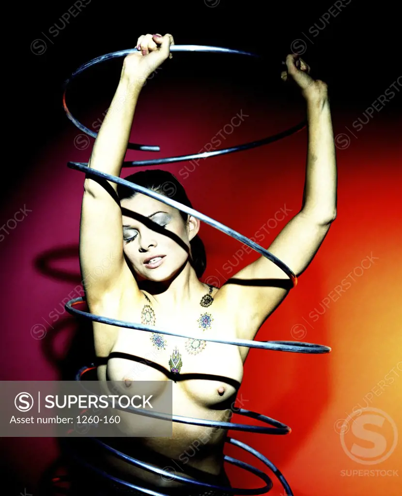 Young naked woman dancing with a tube around her body - SuperStock