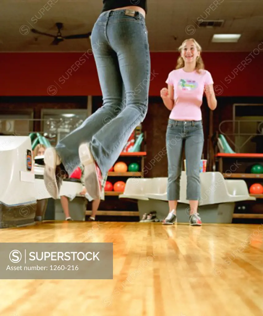 Two teenage girls bowling