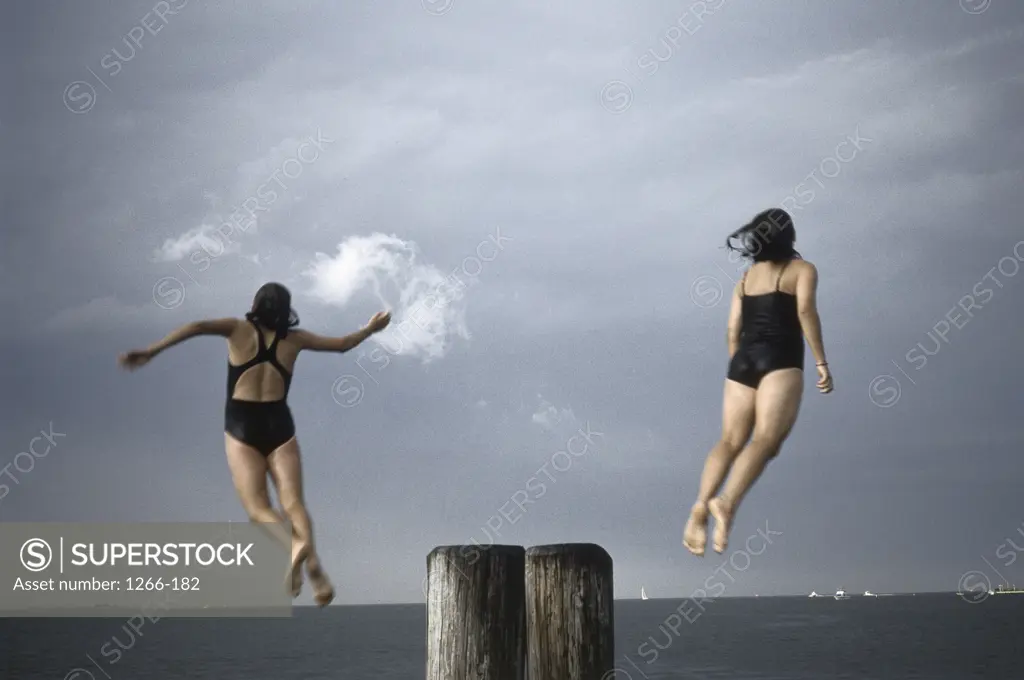 Girls jumping off dock into water