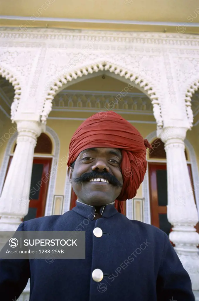 Portrait of a security guard standing in front of the City Palace, Jaipur, Rajasthan, India