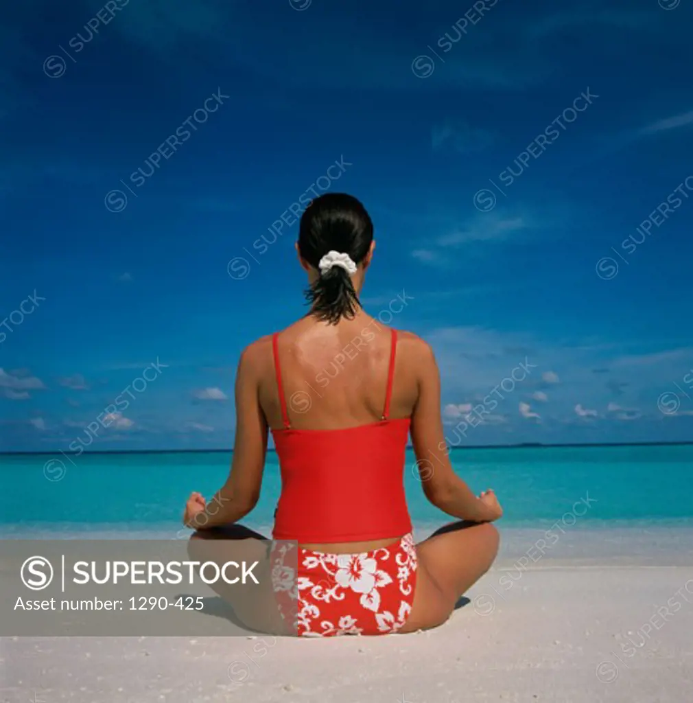 Rear view of a young woman in a lotus position