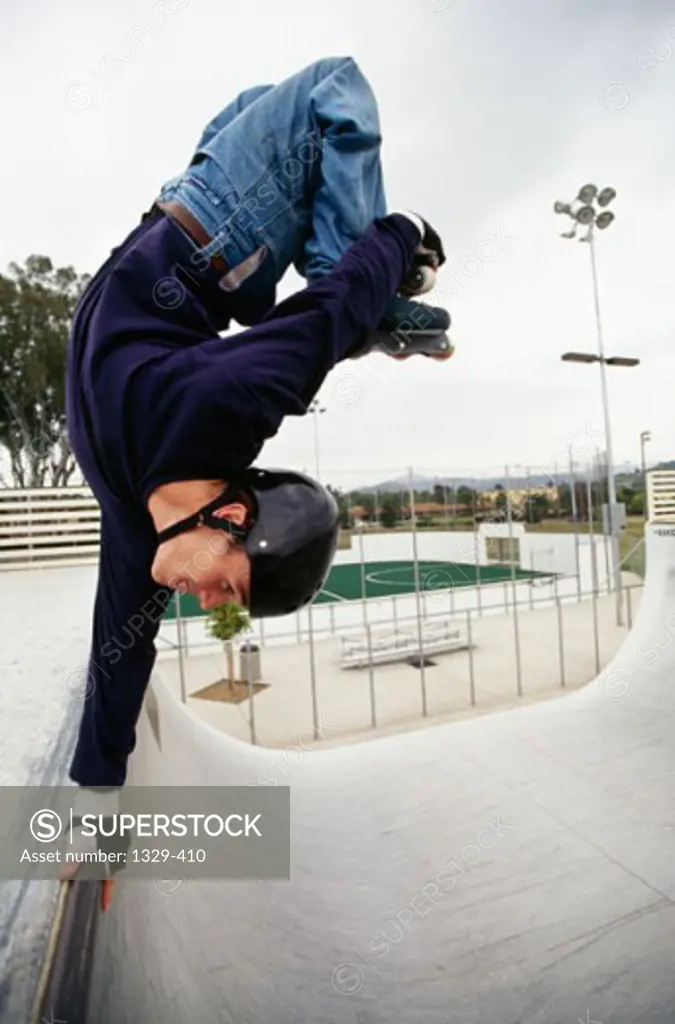 Side profile of a young man performing stunts with inline skates