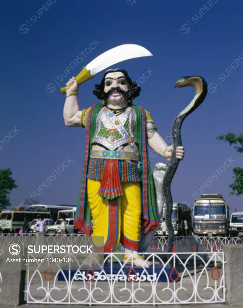 Statue of a demon holding a snake and a sword, Statue of the Demon Mahishasura, Chamundi Hills, Mysore, Karnataka, India