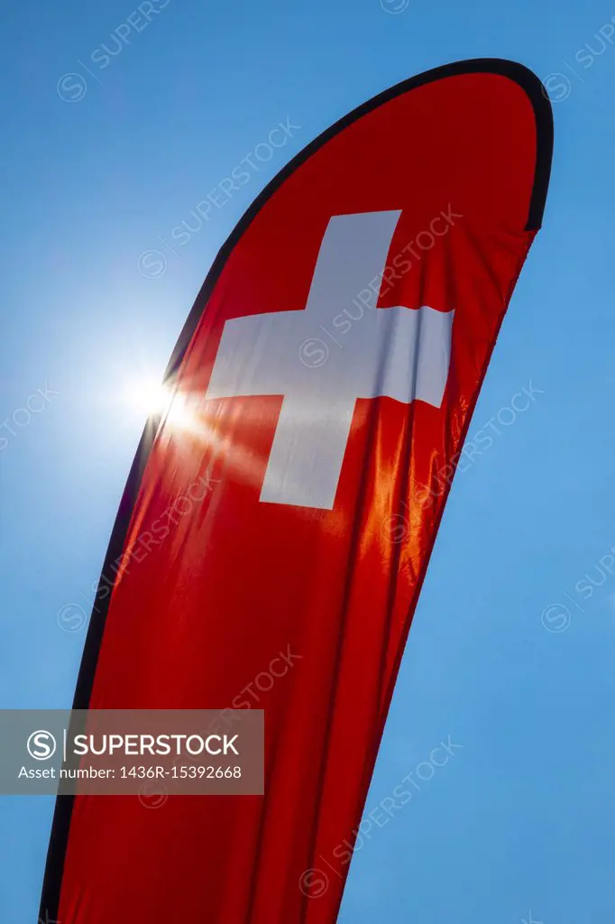 Swiss Banner Flag with Sunlight and Against Blue Sky in Switzerland.