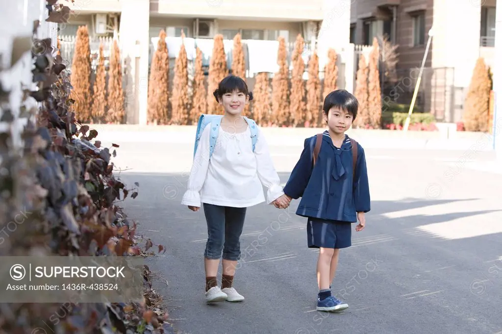 Two kids walking on road