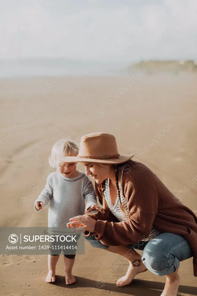 Mother and toddler playing on beach