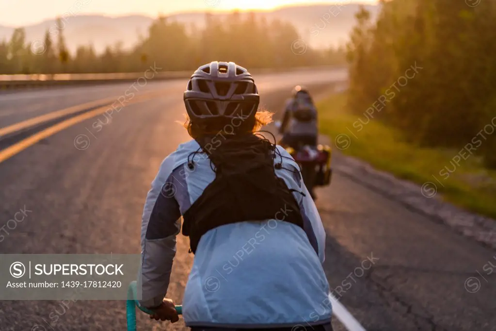 Cyclists on road at sunset, Ontario, Canada