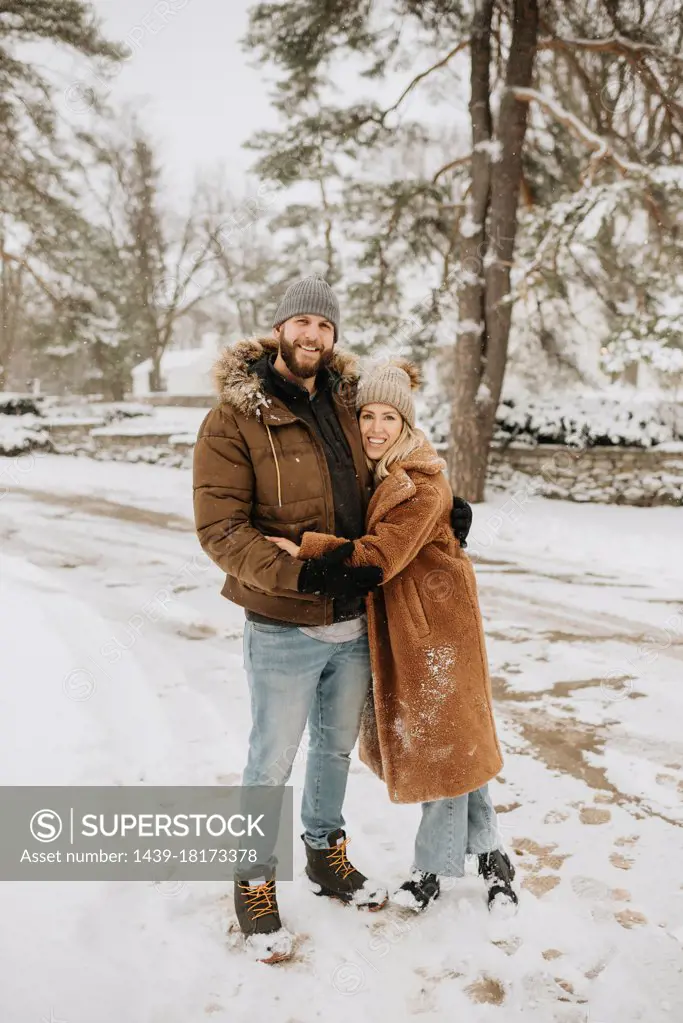 Canada, Ontario, Hugging couple standing on snowy road