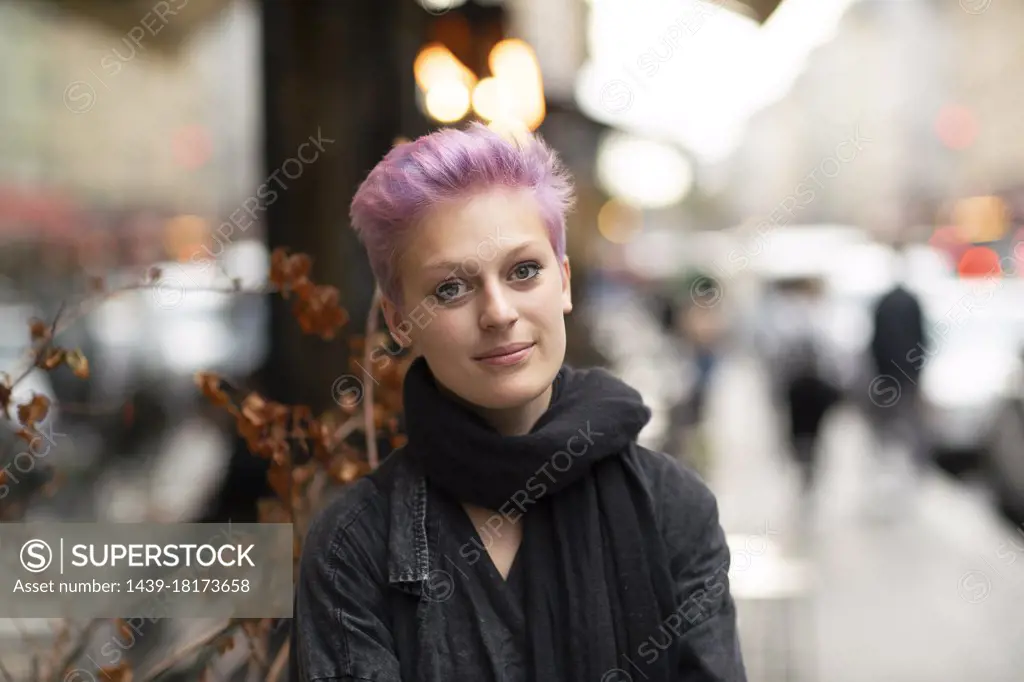 Portrait of young woman on city street