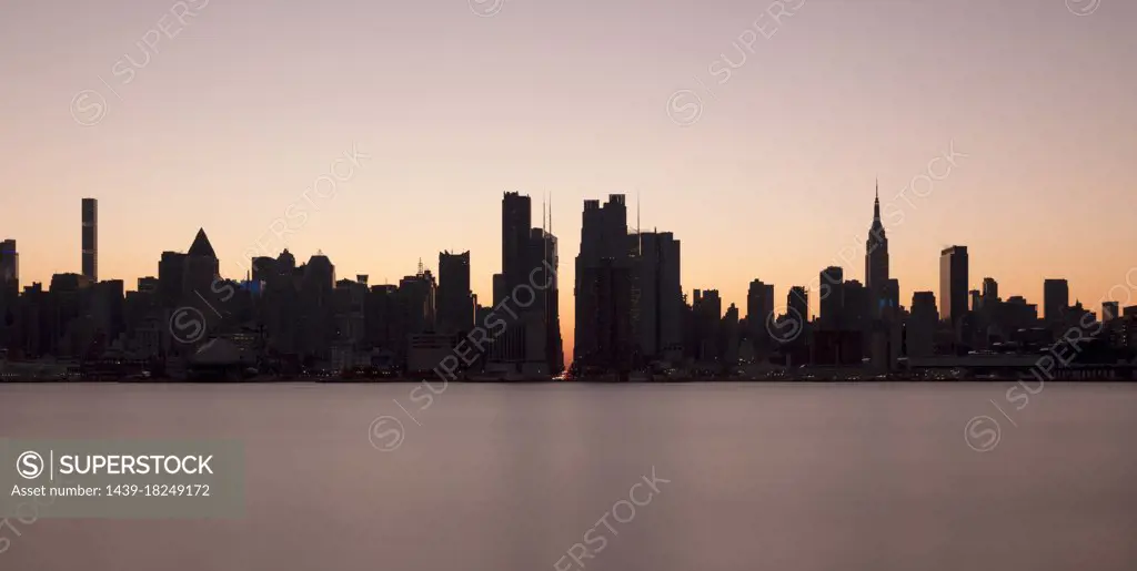 USA, NY, New York City, Midtown Manhattan seen across river at sunset