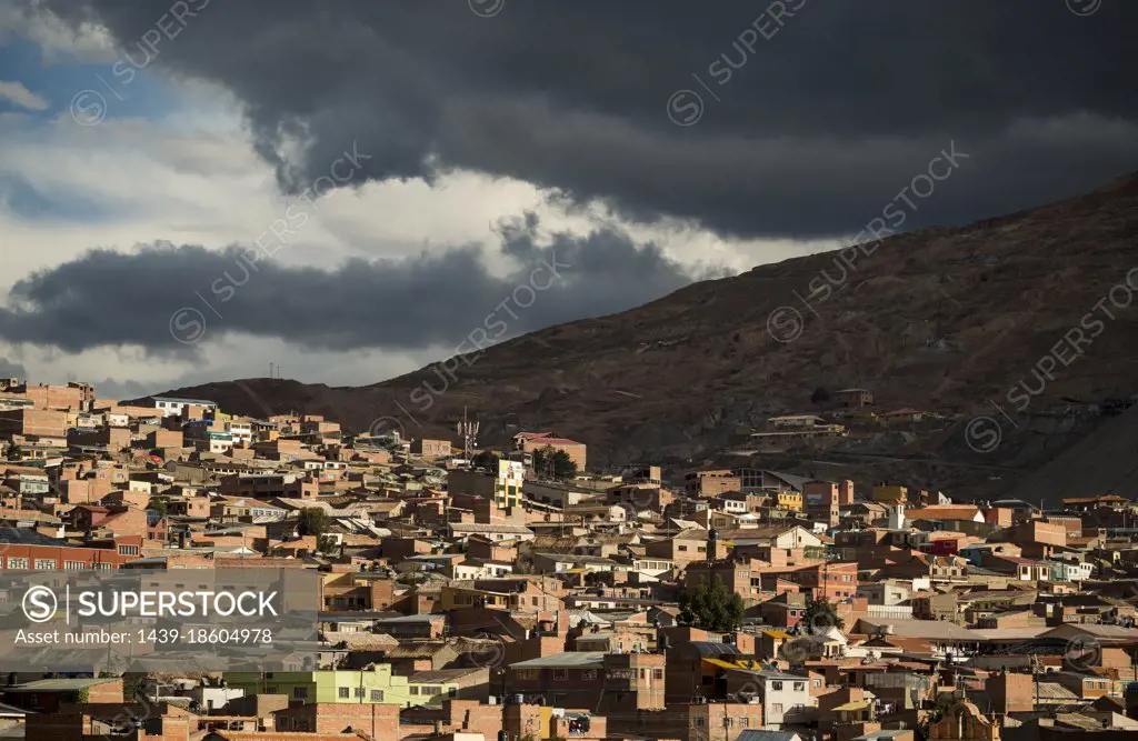 Bolivia, Potosi, Aerial view of city buildings and hill under storm clouds