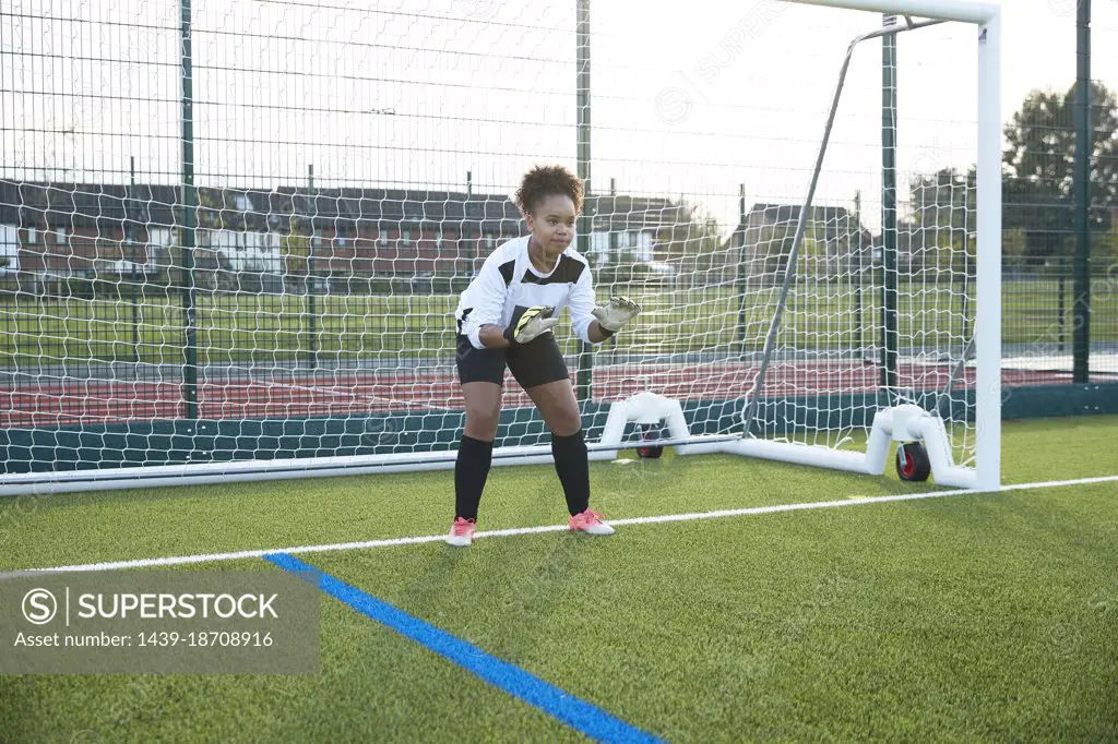 UK, Female soccer goalie defending goal