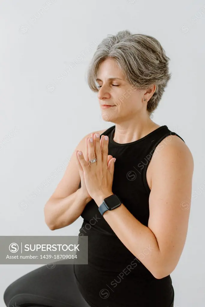 Studio shot of woman meditating with hands clasped