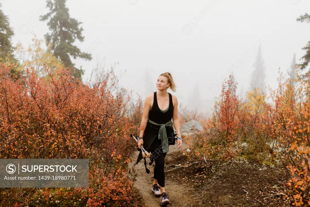 Canada, Yukon, Whitehorse, Woman hiking on footpath in foggy landscape