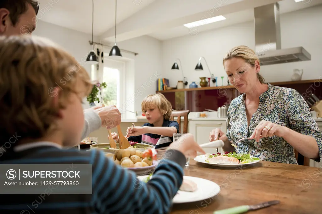 Family sitting down and eating a healthy meal together