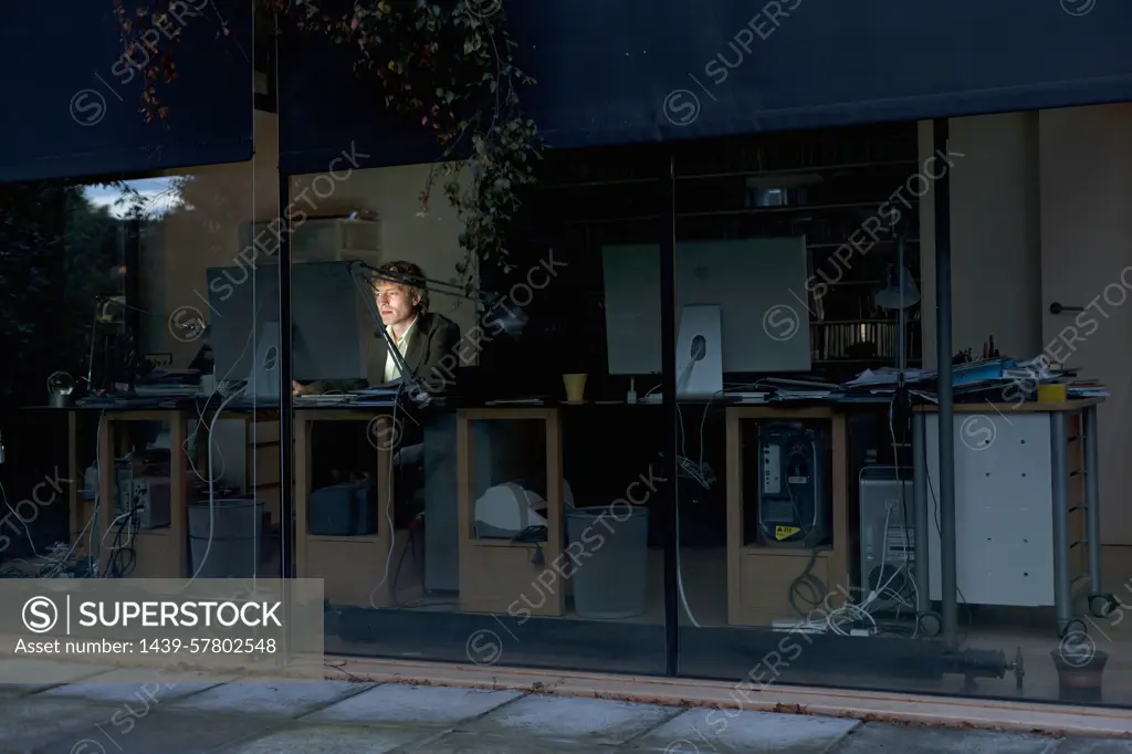 Young man at home working late on computer