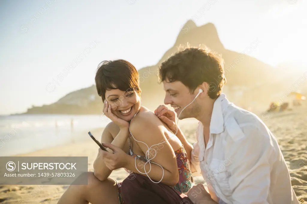 Young couple listening to music, Ipanema Beach, Rio, Brazil