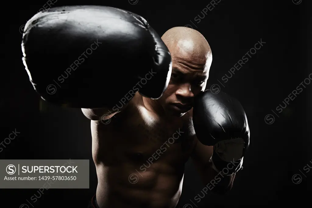 Boxer with black boxing gloves punching towards camera