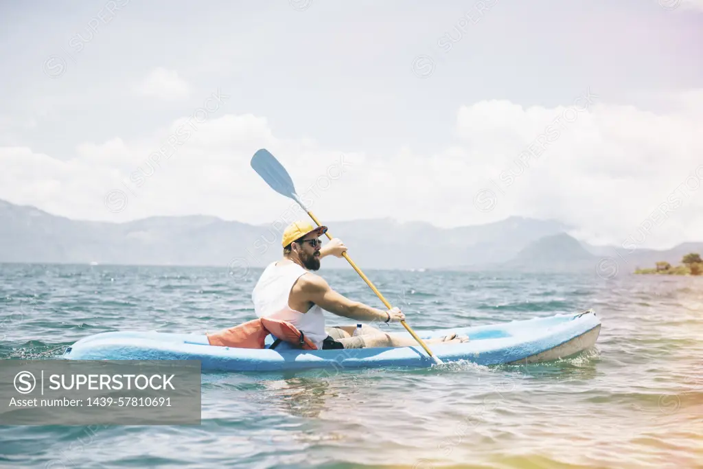 Young man kayaking on  Lake Atitlan, Guatemala