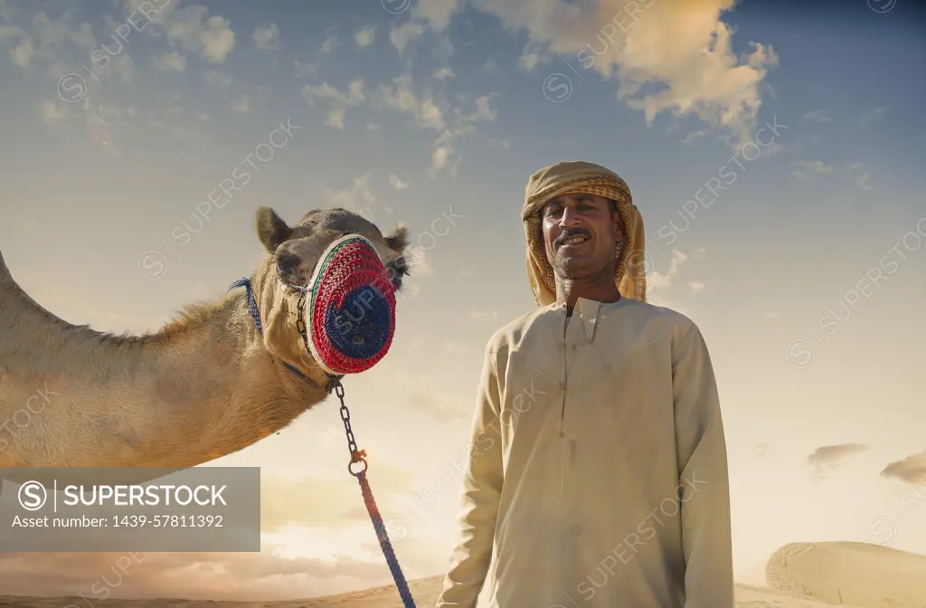 Portrait of camel and bedouin in desert, Dubai, United Arab Emirates