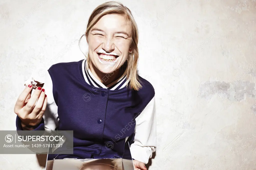 Studio shot of young woman eating chocolate marshmallows