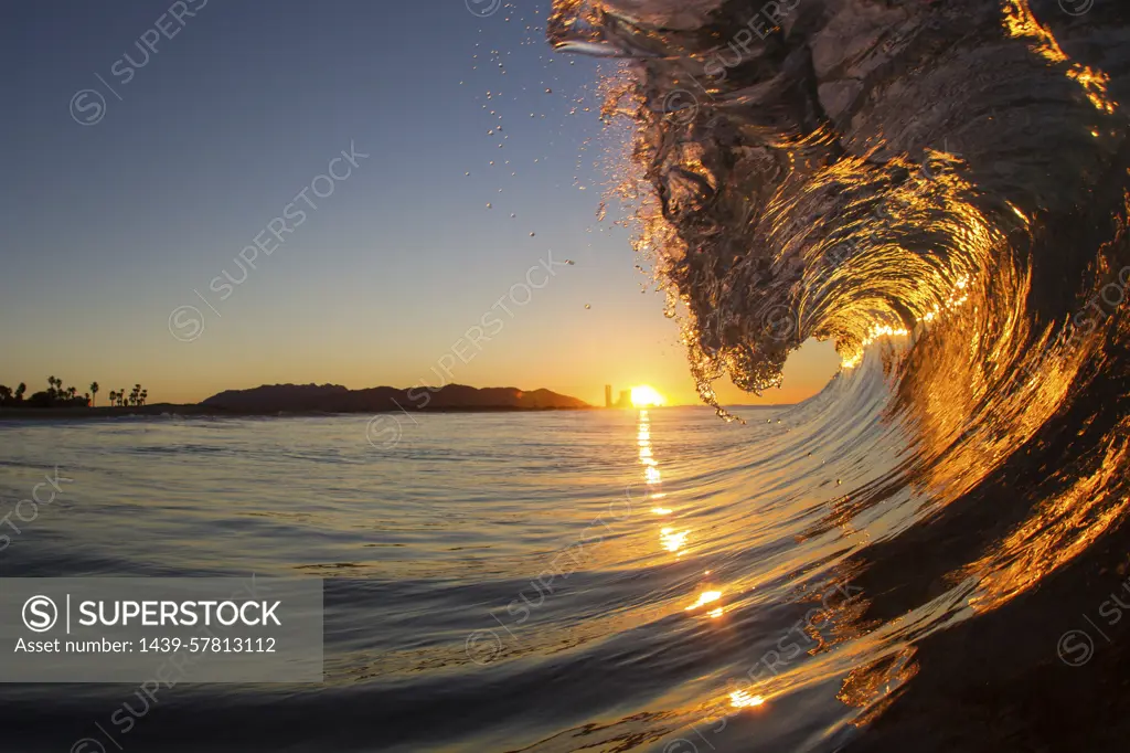 Barrelling wave at sunset, Hawaii