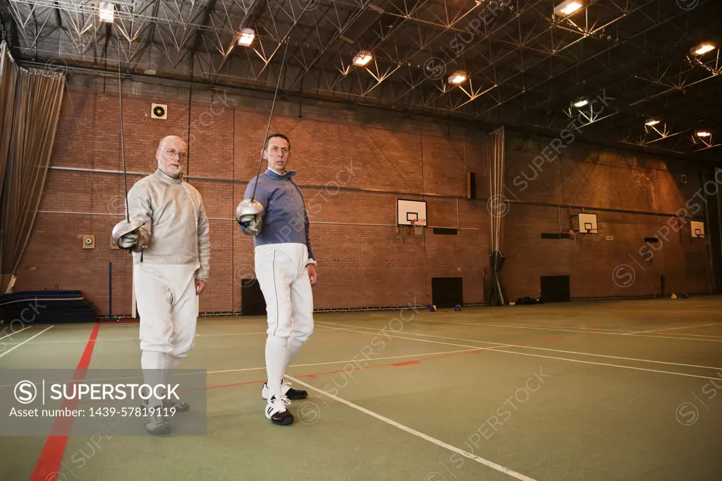 Two fencers take a break during practice.