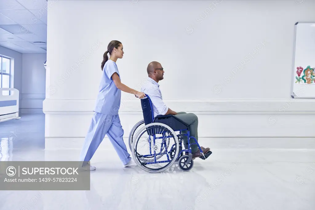 Doctor in hospital pushing patient in wheelchair