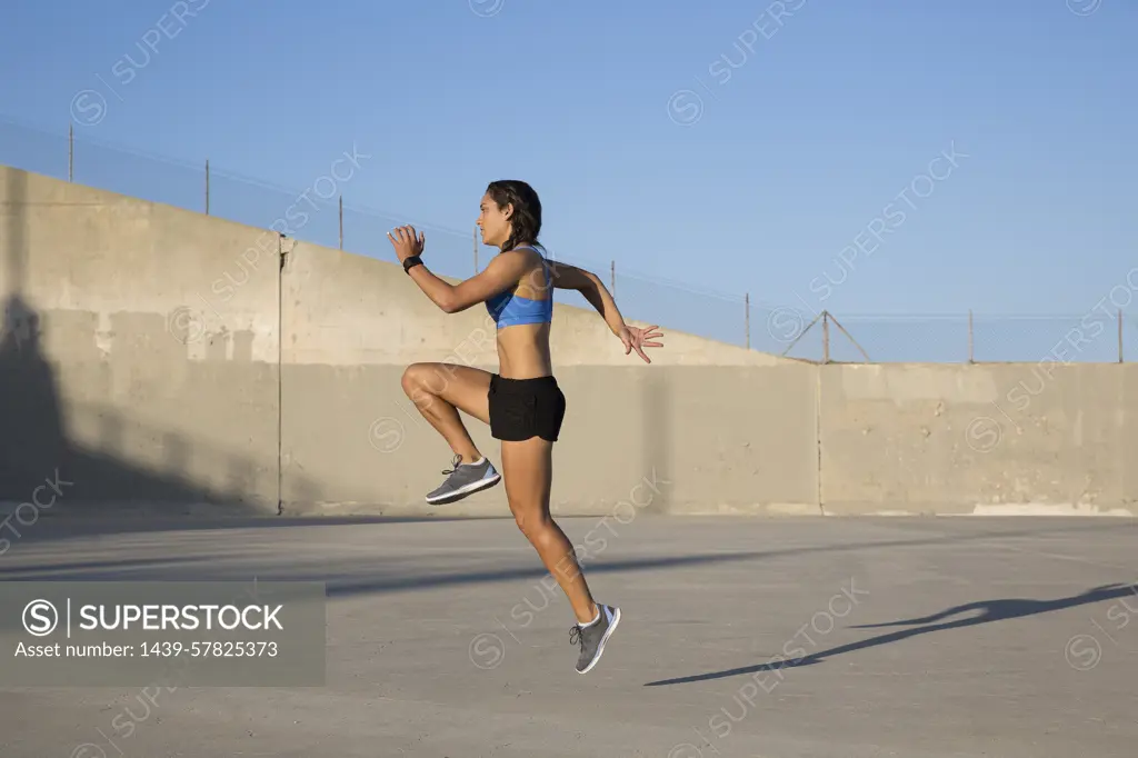 Female athlete doing high knees exercise, Van Nuys, California, USA