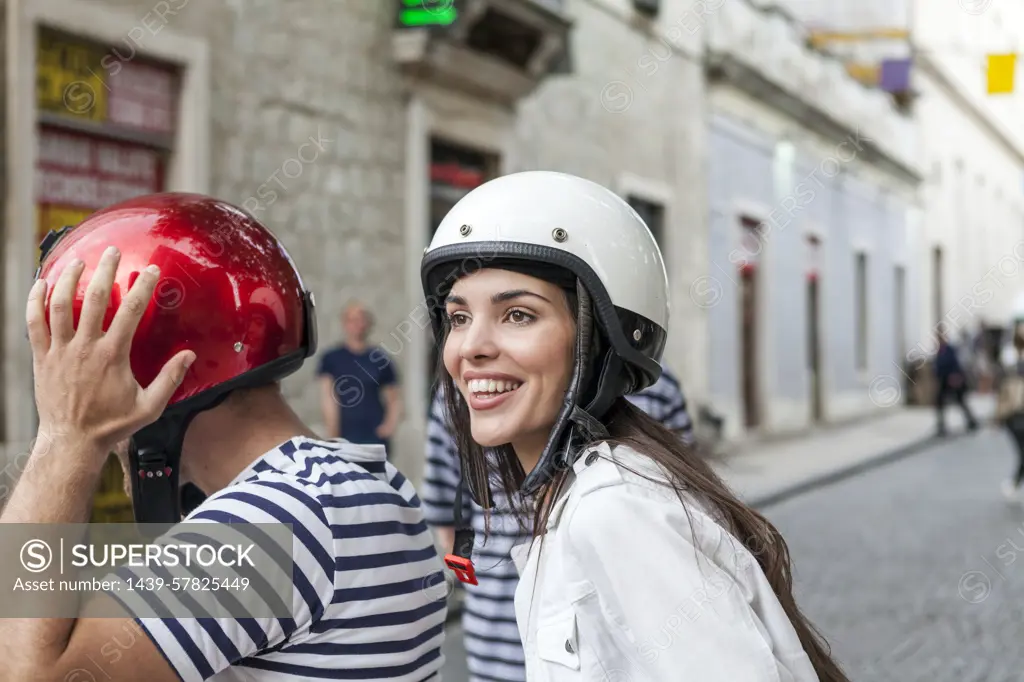 Young couple riding moped through village, Split, Dalmatia, Croatia