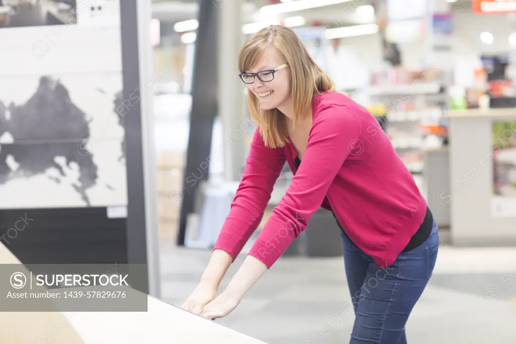 Female customer opening chest of drawers in hardware store