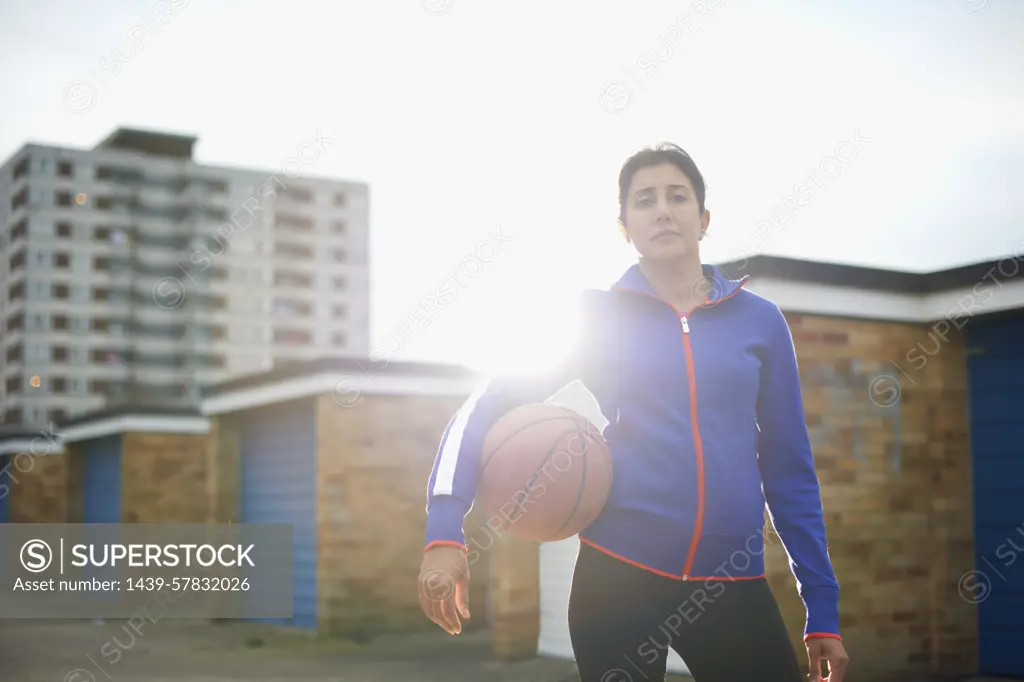 Portrait of mature female basketball player holding ball