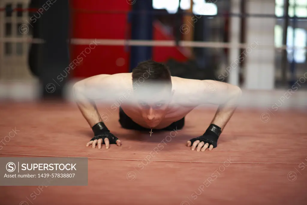 Boxer doing push-ups in boxing ring