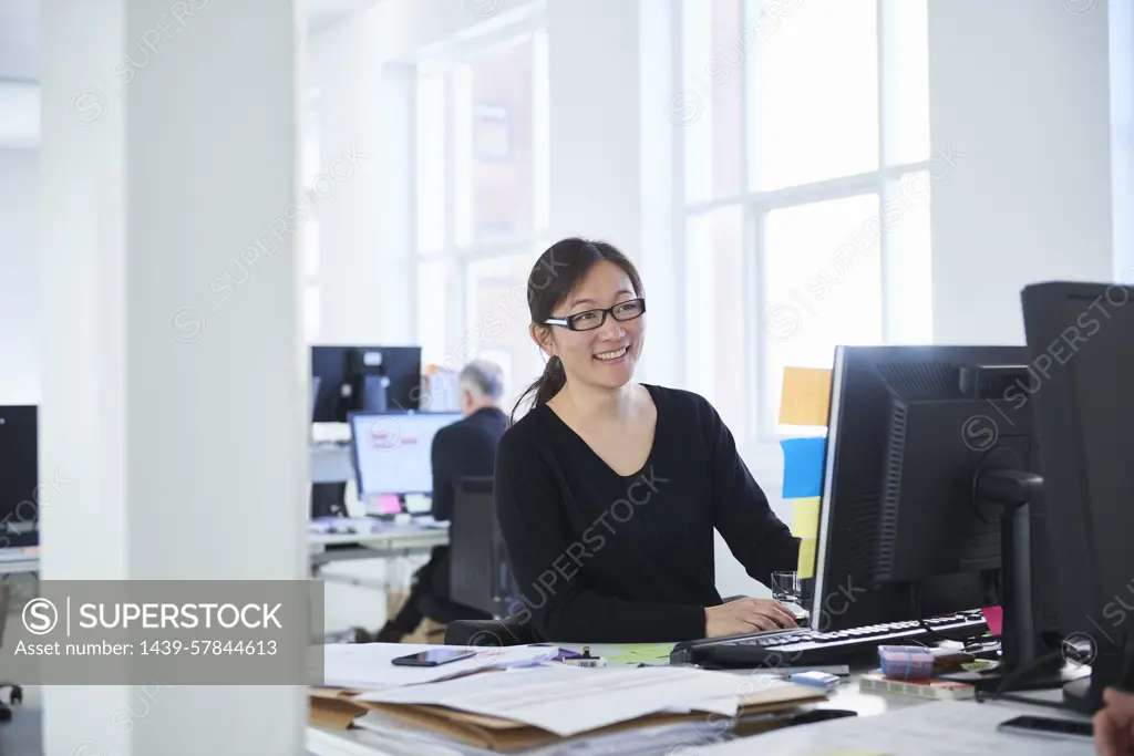 Woman working in office, using computer