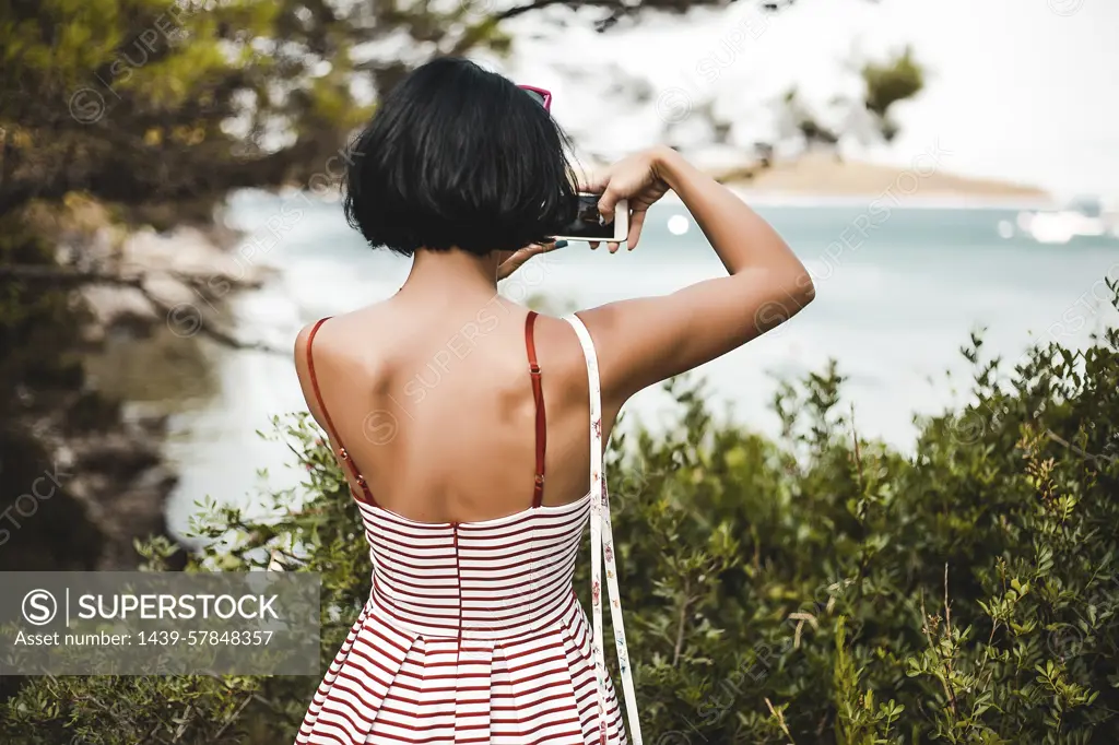 Woman taking photograph of coast, Koralat, Zagrebacka, Croatia