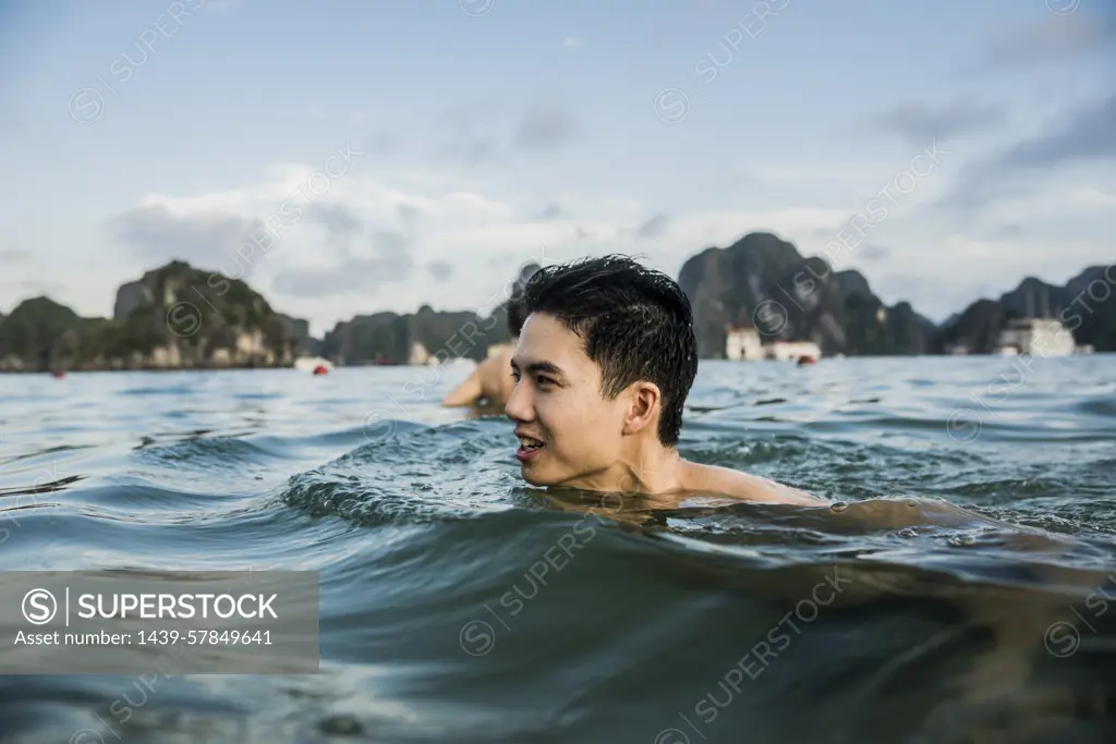 Man swimming in waters of Ha Long Bay, Vietnam