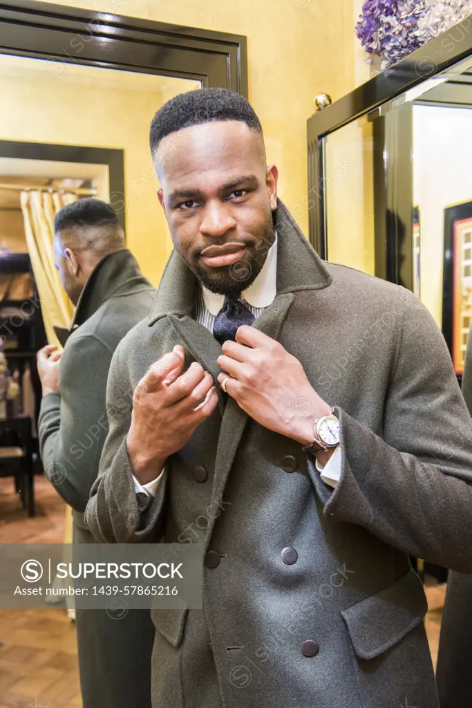 Male customer trying on coat in tailors shop, portrait